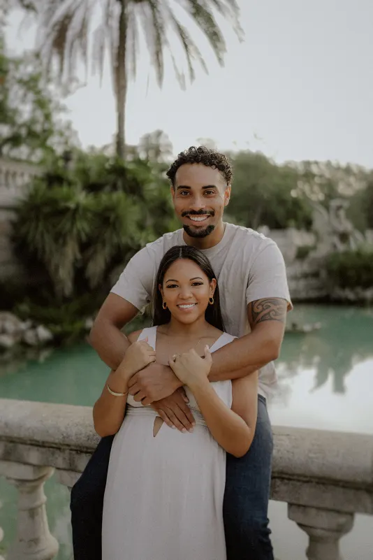 Smiling couple embraces by the water at Parc de la Ciutadella during a relaxed couples & engagements photoshoot.