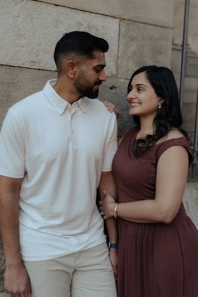 Smiling couple gazes at each other, sharing a quiet, affectionate moment during a couples & engagement photoshoot.