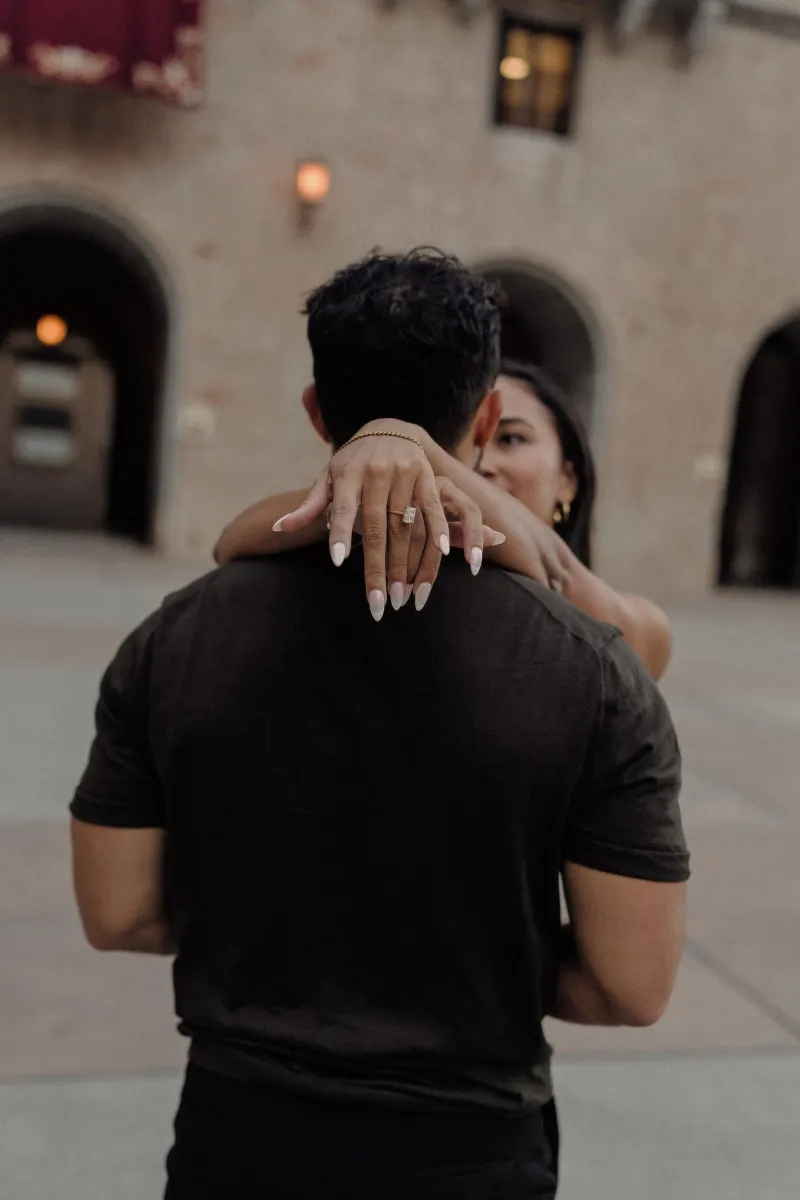 Sydney’s engagement ring is visible as she embraces Dan in the monastery square.