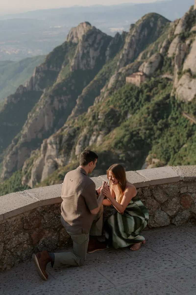 Tim and Megan hold hands beside the stone parapet during the proposal.