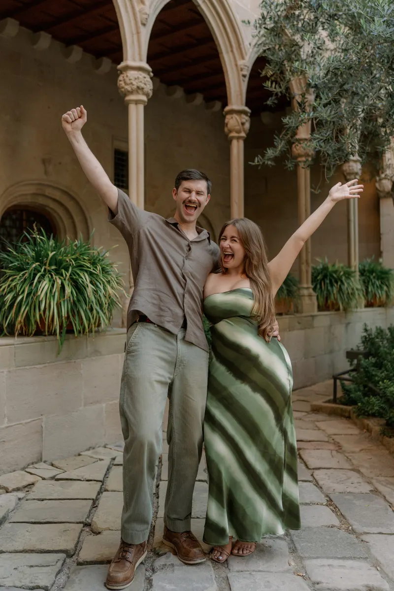 Tim and Megan raise their arms together in the cloister garden.