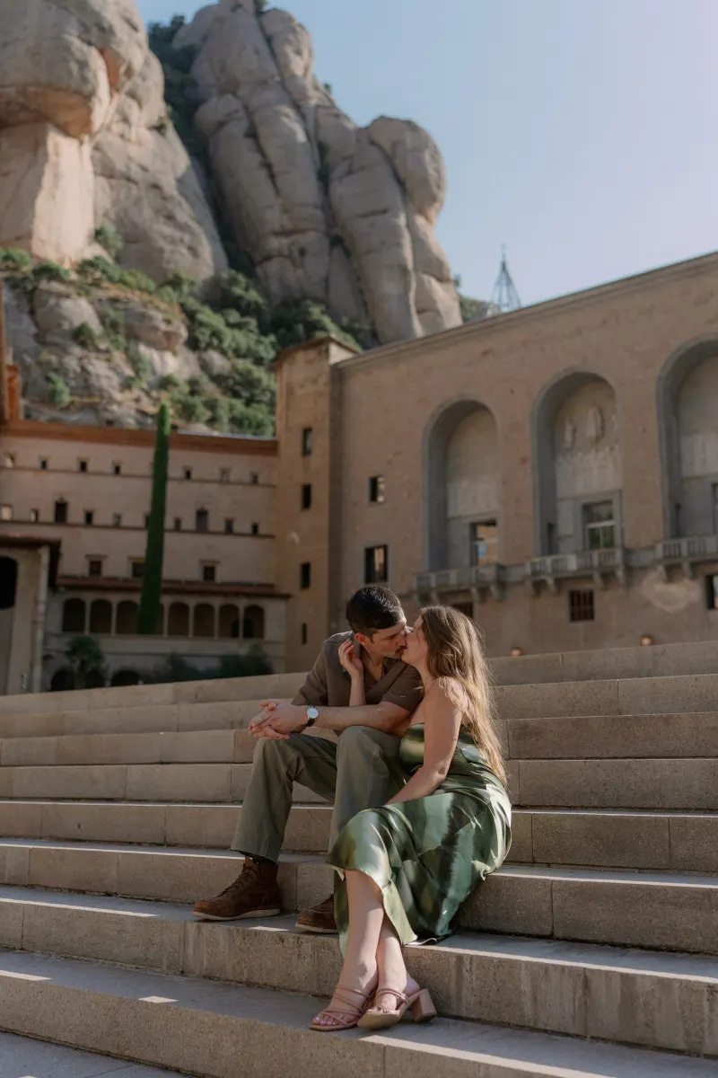 Tim and Megan sit closely together on the monastery's broad stone steps.