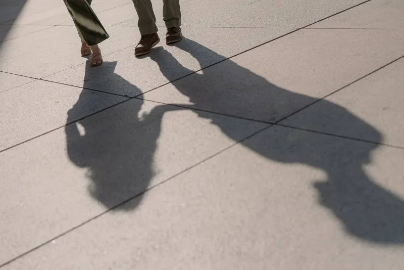 Tim and Megan's shadows stretch across the sunlit paving.