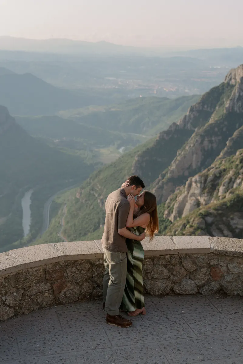 Tim embraces Megan with the hazy valley behind them.