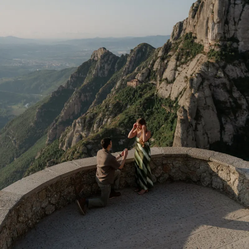 Tim kneels to propose to Megan at a mountain viewpoint in Montserrat.