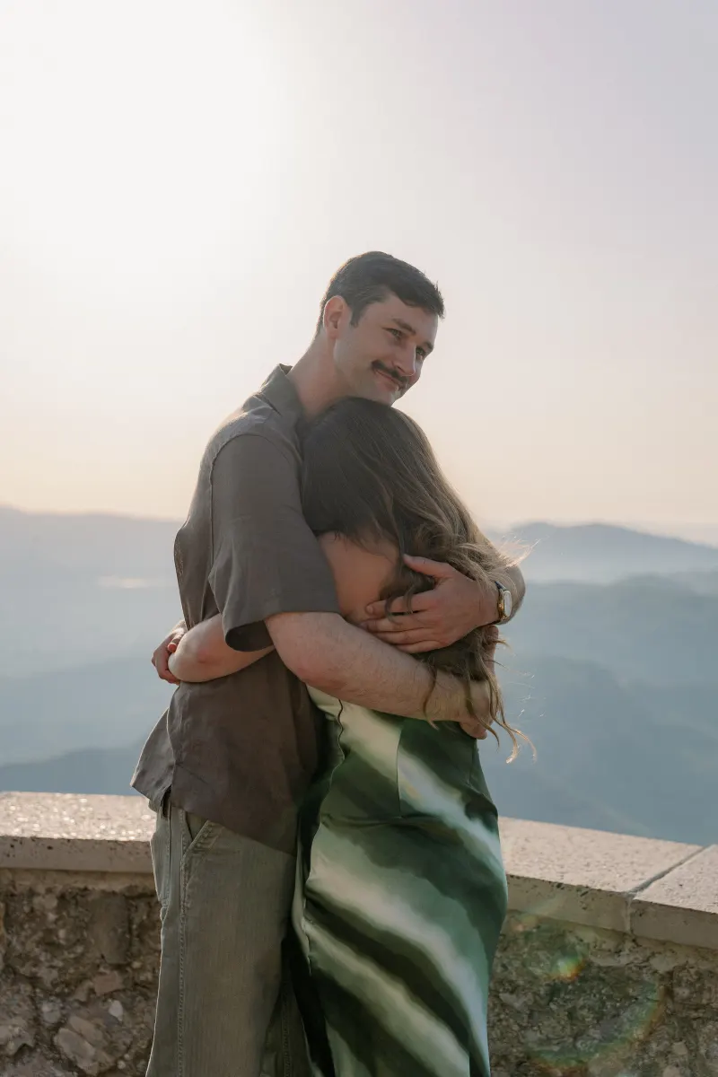 Tim wraps his arms around Megan at the viewpoint.