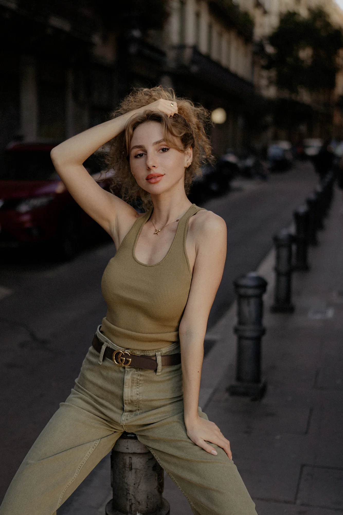 Young woman poses confidently on a city street during a Vacation Portraits photoshoot, capturing relaxed urban style.