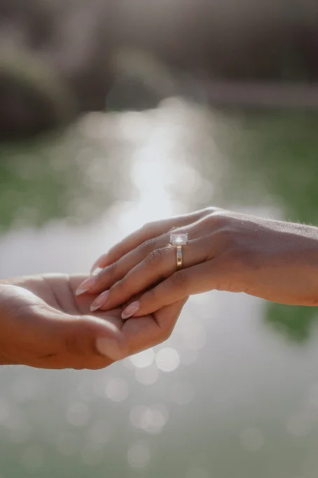 A couple holds hands by the water at Park de la Ciutadella, capturing a romantic engagement moment.