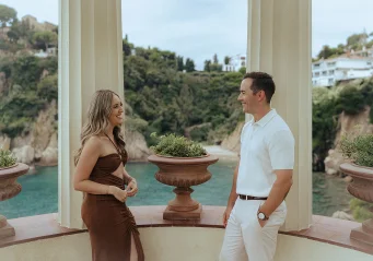 A couple shares a joyful moment at Marimurtra Garden, perfect for engagement photography.