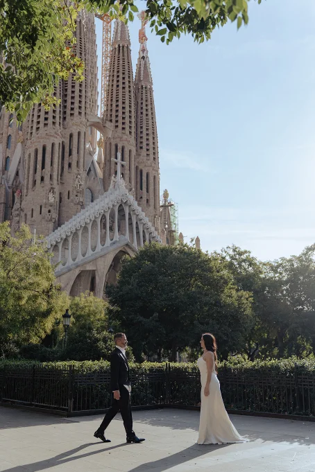 Bride and groom share a romantic moment in front of La Sagrada Familia, captured by a professional photographer.