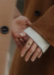 Close-up of hands gently touching, adorned with rings, captured in the Born area for a lifestyle photography session.