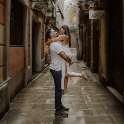 Couple embraces joyfully in a romantic Born area alley, captured by a professional engagement photographer.