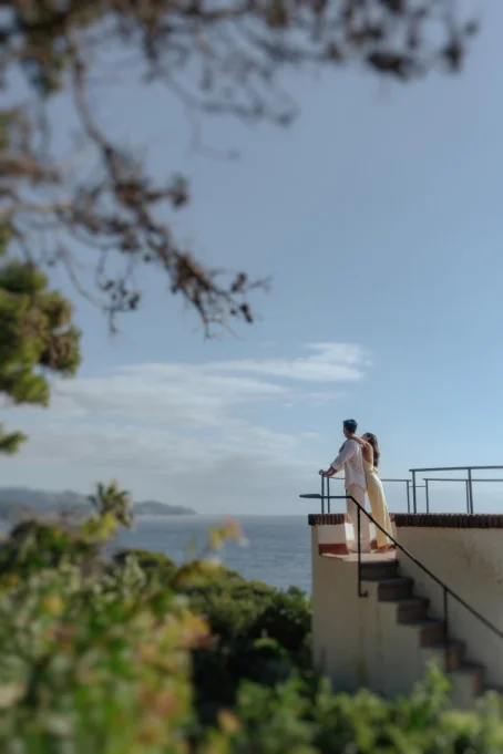 Couple embraces on a terrace overlooking the sea at Marimurtra garden, captured for a location photography gallery.