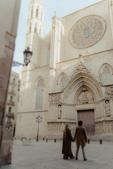 Couple holding hands and admiring the historic Santa Maria del Mar in the Born area, captured during a location photoshoot.
