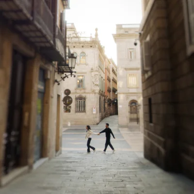 Couple holding hands and laughing while exploring the charming streets of the Gothic Quarter, captured during a photo session