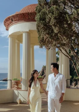 Couple holding hands and smiling at each other in Marimurtra Garden, perfect for engagement photography.