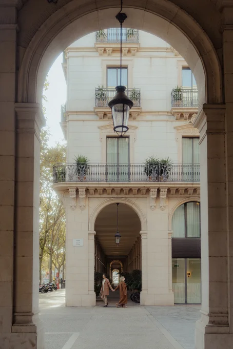 Couple holding hands under elegant archways in the Born area, captured during a location photography session.