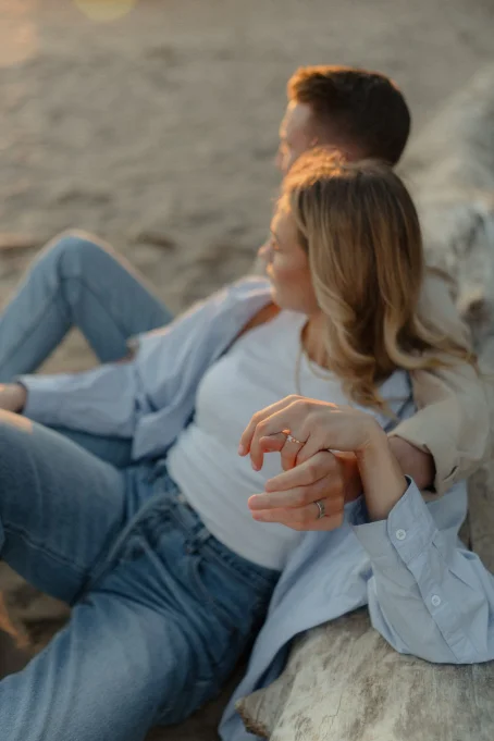 Couple relaxing on Ginesta beach, holding hands and enjoying a golden sunset during a romantic photo session.