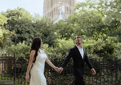 Couple shares a romantic dance pose in front of La Sagrada Familia, captured by a professional photographer.