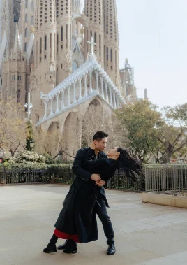Couple shares a romantic dance pose in front of La Sagrada Familia, captured during a professional photoshoot.