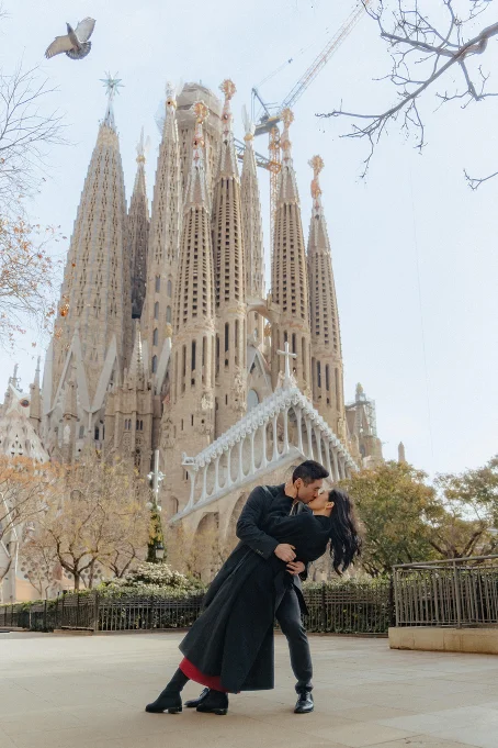 Couple shares a romantic kiss in front of La Sagrada Familia, captured by a professional photographer in Barcelona.