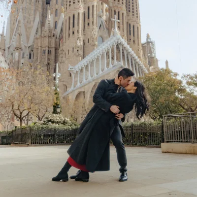 Couple shares a romantic kiss in front of La Sagrada Familia, captured during a professional couples photoshoot.