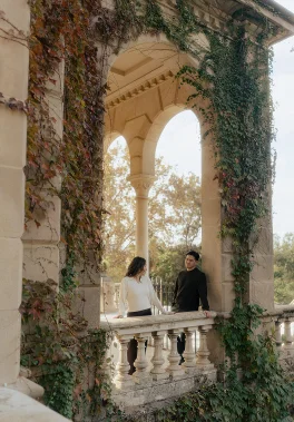 Couple sharing a joyful moment on a vine-covered terrace at Park de la Ciutadella, perfect for engagement photography.
