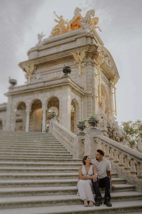 Couple sharing a joyful moment on the grand steps at Park de la Ciutadella, perfect for engagement photography sessions.