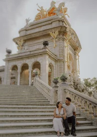 Couple sharing a joyful moment on the steps of Park de la Ciutadella, perfect for engagement photography in Barcelona.