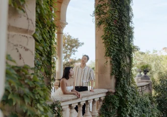 Couple sharing a quiet moment on a vine-covered balcony at Park de la Ciutadella, captured during a romantic photoshoot.
