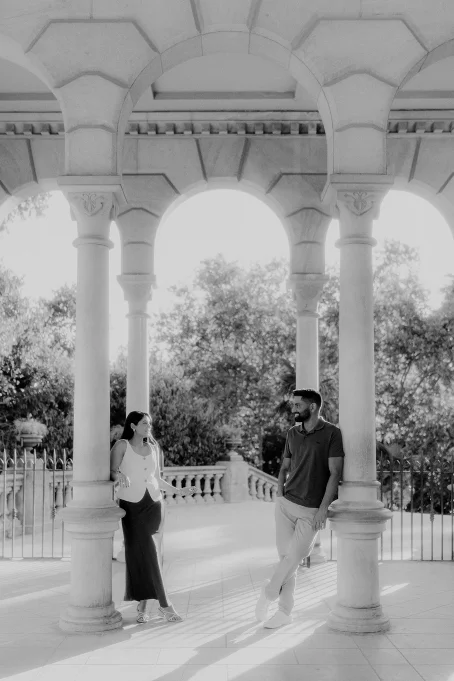Couple sharing a relaxed moment under elegant arches at Park de la Ciutadella, perfect for engagement photography.