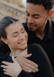 Couple sharing a warm embrace and smiling at Park de la Ciutadella, captured during a romantic portrait session.