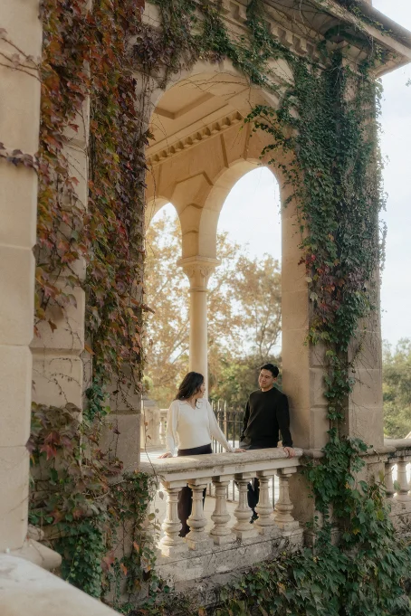Couple sharing a warm moment on a vine-covered balcony at Park de la Ciutadella, captured during a lifestyle photoshoot.