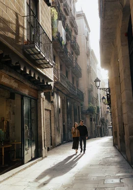 Couple walking hand in hand through sunlit Gothic Quarter street, perfect for romantic portrait photography sessions.