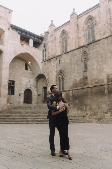 Elegant couple embraces in the Gothic Quarter, capturing a romantic moment for a professional portrait session.