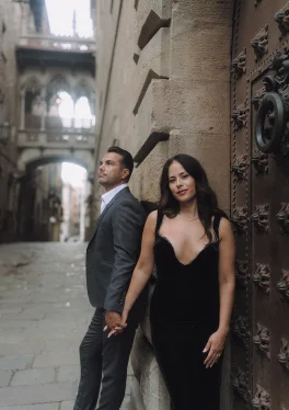 Elegant couple holding hands in the Gothic Quarter, capturing a romantic moment for a professional portrait session.