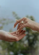 Engagement moment at Marimurtra Garden, hands reaching tenderly with a sparkling ring, capturing love and connection.