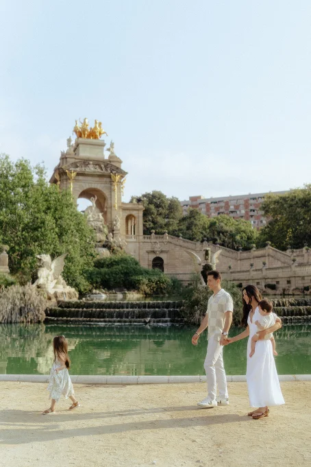 Family enjoying a sunny stroll by the fountain at Park de la Ciutadella, captured during a lifestyle photography session.