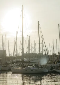 Golden hour light over sailboats docked at Port Vell, capturing tranquil moments by the Barceloneta waterfront.