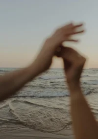 Hands intertwined at sunset on Ginesta beach, capturing intimate moments for a couples photography session.