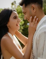 Joyful couple sharing a romantic moment in Marimurtra Garden, captured during an engagement photography session.