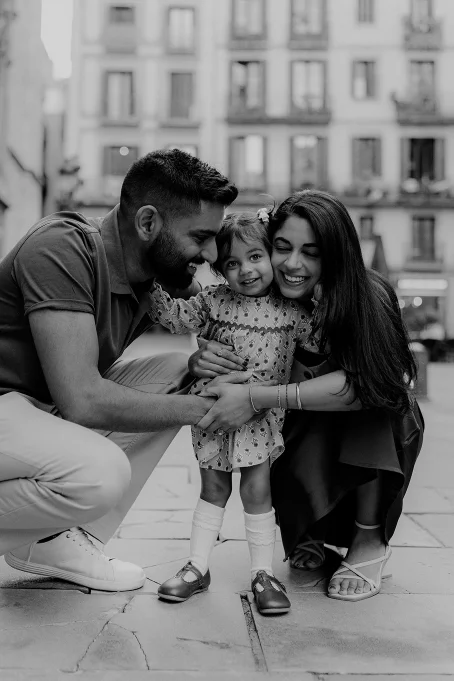 Joyful family portrait in the Born area, parents hugging their smiling daughter during a location photography session.