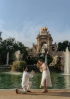 Man proposes to his partner by the fountain at Park de la Ciutadella, capturing a joyful engagement moment.