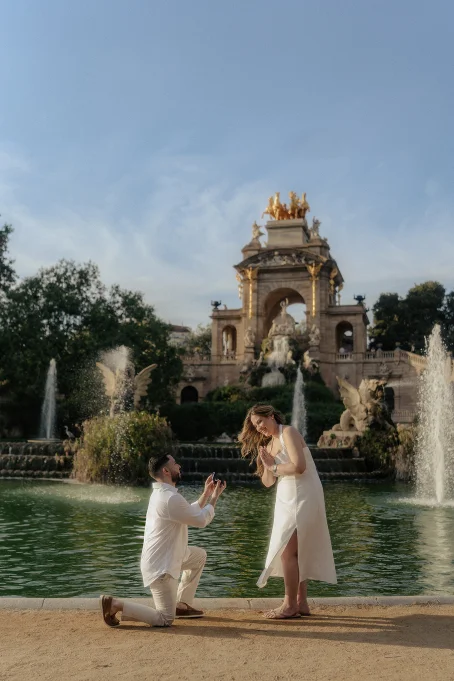 Romantic proposal at Park de la Ciutadella, couple sharing a joyful moment by the fountain, engagement photography.