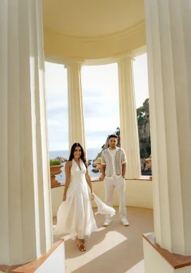 Smiling couple in elegant white outfits pose at Marimurtra Garden, perfect for romantic or engagement photography sessions.