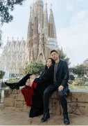 Stylish couple poses together in front of La Sagrada Familia, capturing a romantic moment for a portrait session.