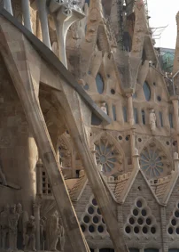 Warm sunlight highlights the intricate stonework and sculptures of La Sagrada Familia’s iconic façade in Barcelona.