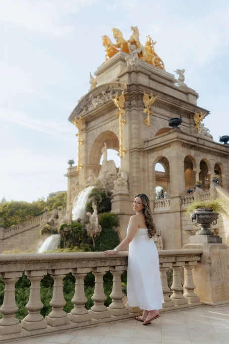 Woman in a white dress smiles by the fountain at Park de la Ciutadella, perfect for location portrait photography.