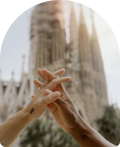 Couple’s hands intertwined after a surprise proposal in front of Sagrada Família, Barcelona.