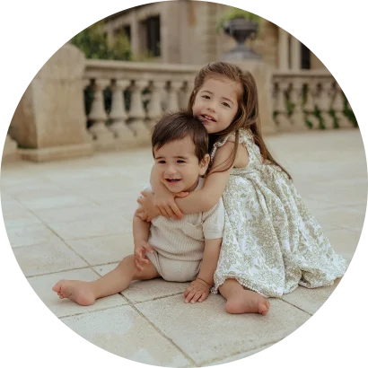 Smiling siblings share a warm hug during a Vacation Portraits photoshoot in sunny Barcelona.